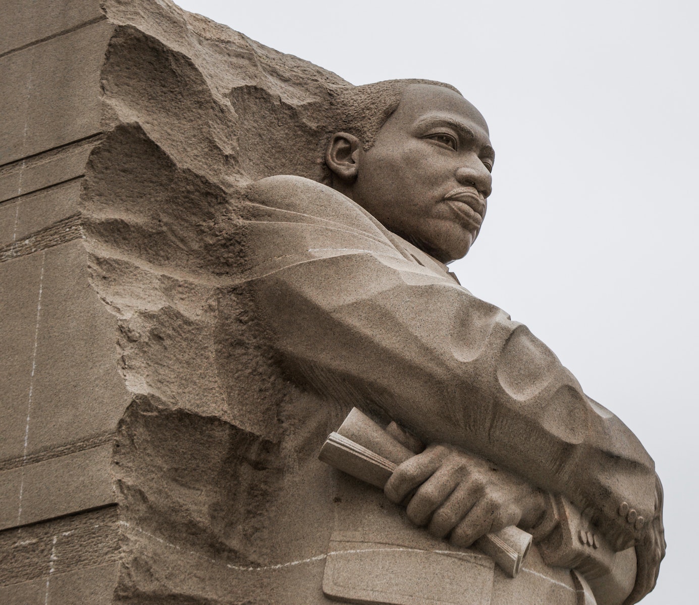 Granite statue of civil rights movement leader against overcast sky, independência, ideologia política